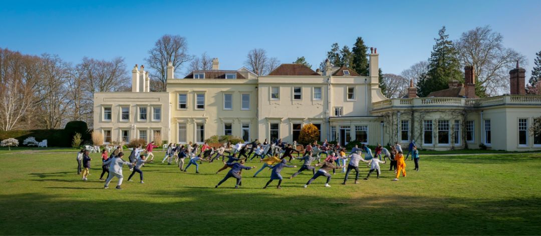 The whole of Brockwood Park School exercising together outdoors